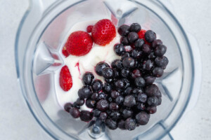 berries, yogurt, and all other smoothie ingredients added to a blender.