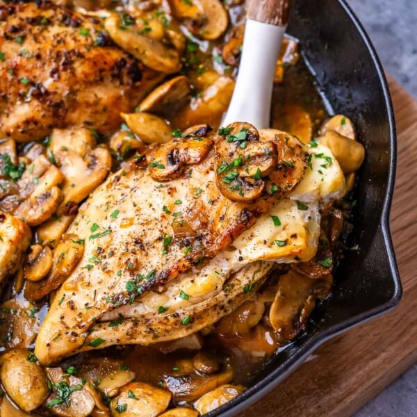 spoon grabbing a serving of stuffed chicken breast with mushrooms.