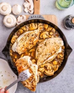 adding stuffed chicken breast in pan with mushroom sauce.