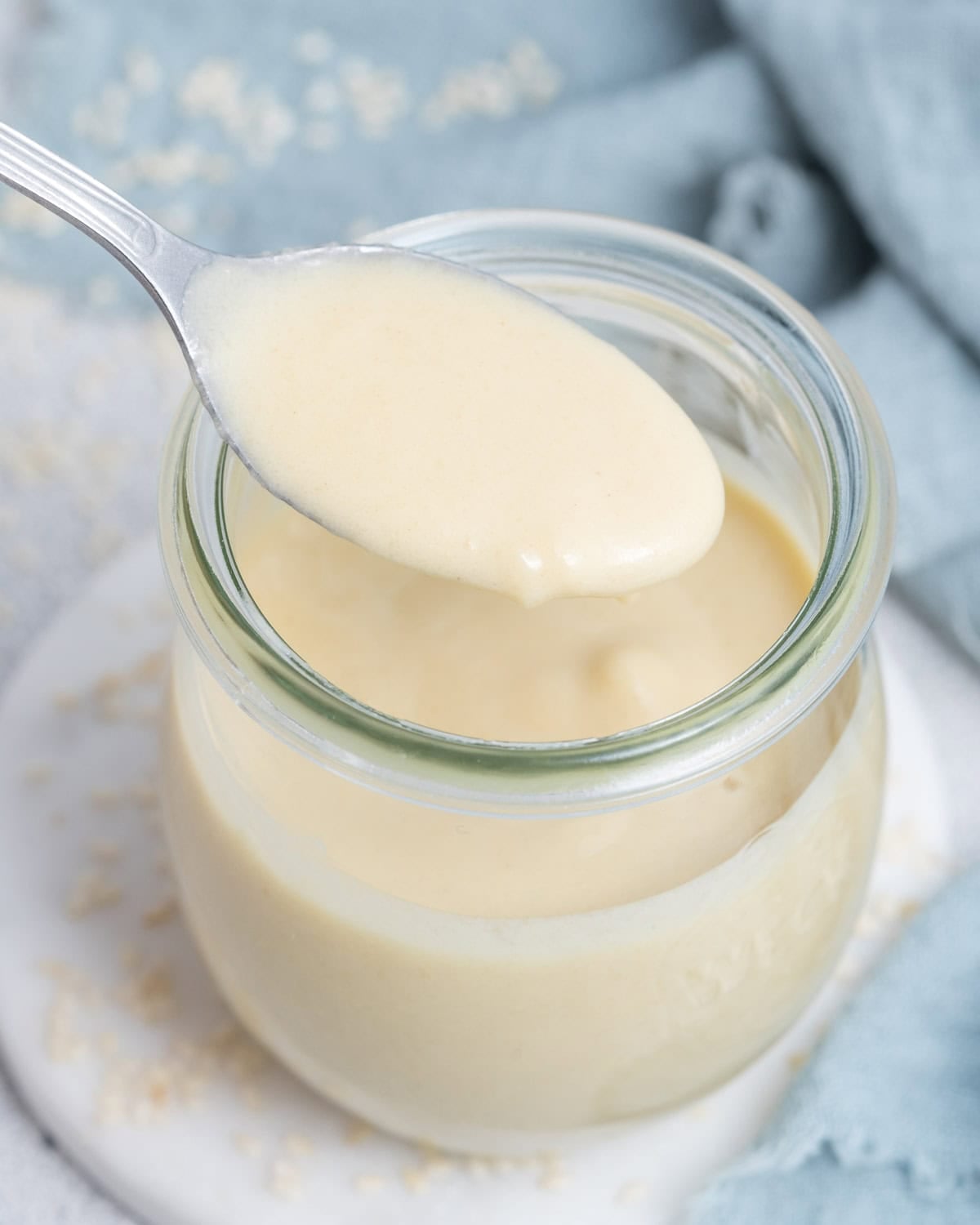 A spoonful of tahini dressing over a jar.