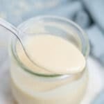 a spoonful of tahini salad dressing over a jar with the dressing.
