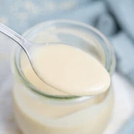 a spoonful of tahini salad dressing over a jar with the dressing.