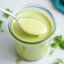a jar with avocado ranch dressing with spoonful.