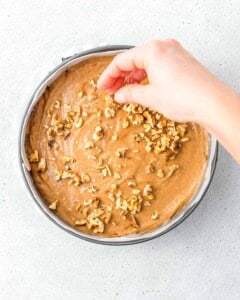 walnuts being added over the date cake batter.