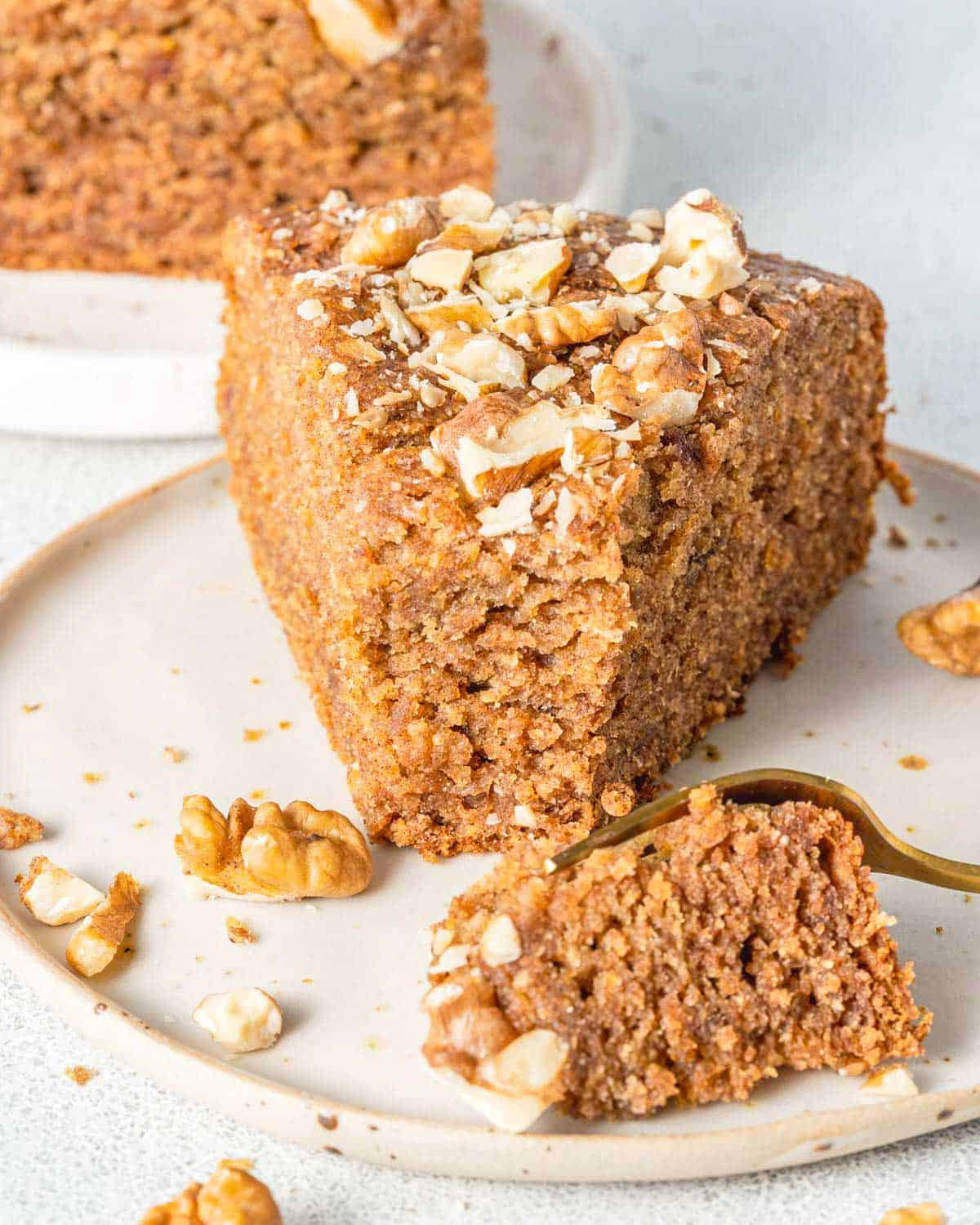 a slice of date and walnut cake on a plate.