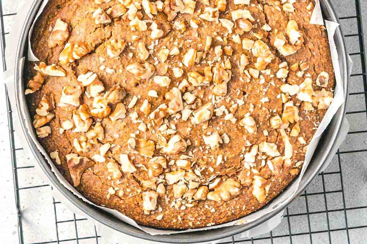 baked date cake in a pan on a wire rack.
