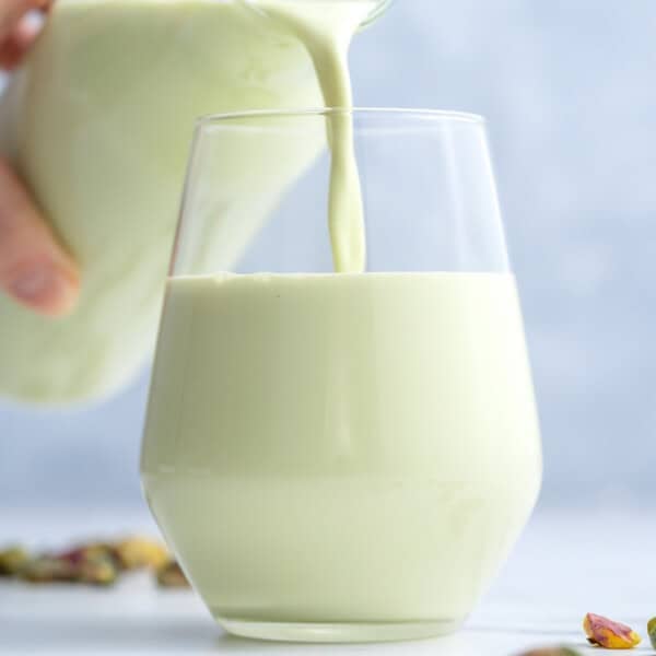 Pouring pistachio milk into a cup.