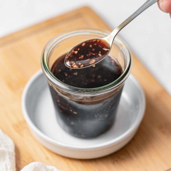 a jar with teriyaki sauce and a spoonful over the jar.