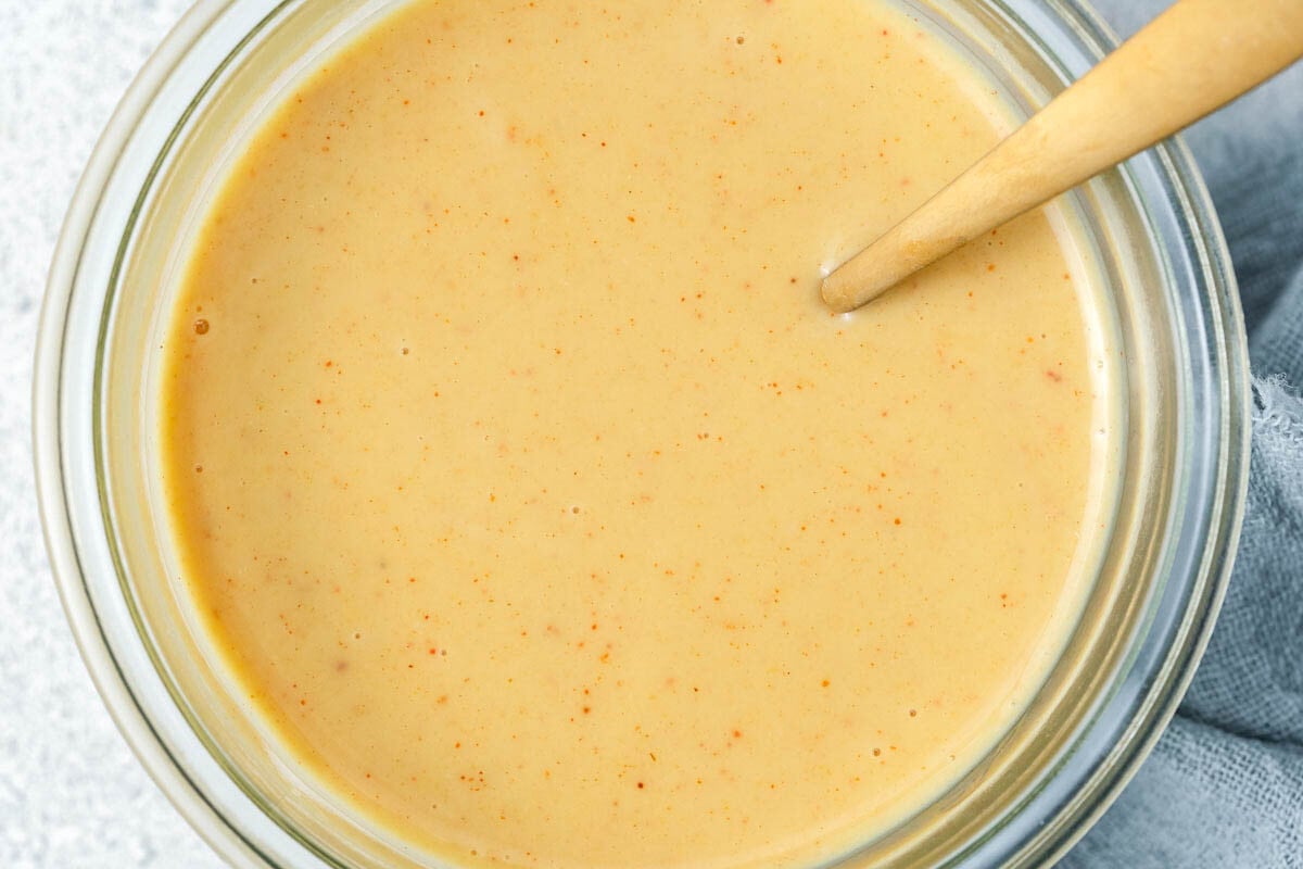 honey mustard sauce in a bowl with a spoon in it.