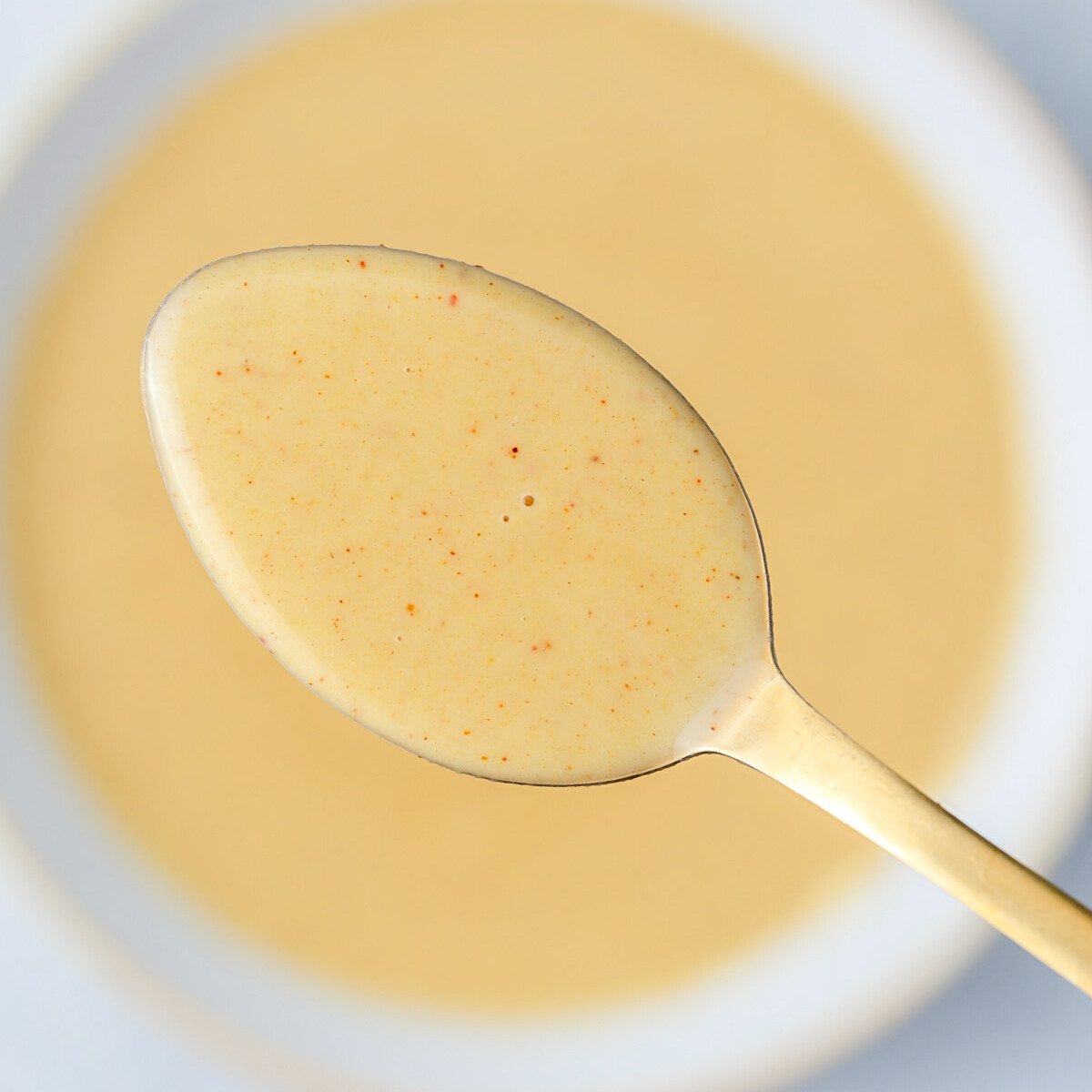 a spoonful of honey mustard sauce over the bowl.