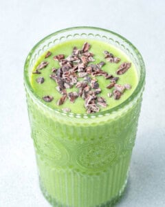 Shamrock shake topped with cocoa nibs in a cup.