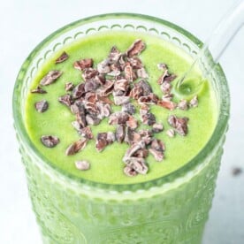 a cup full of shamrock shake topped with cocoa nibs.