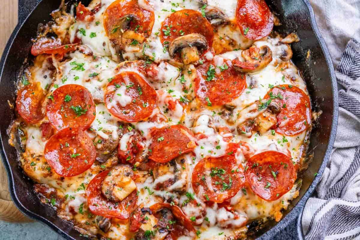 cooked chicken breast topped with melted cheese and pepperoni in a skillet.