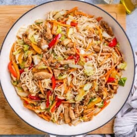 chicken yakisoba noodles in a pan with shredded veggies.