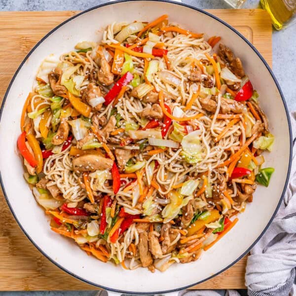 chicken yakisoba noodles in a pan with shredded veggies.