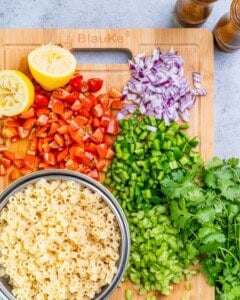 chopped veggies on a cutting board for cowboy pasta salad.
