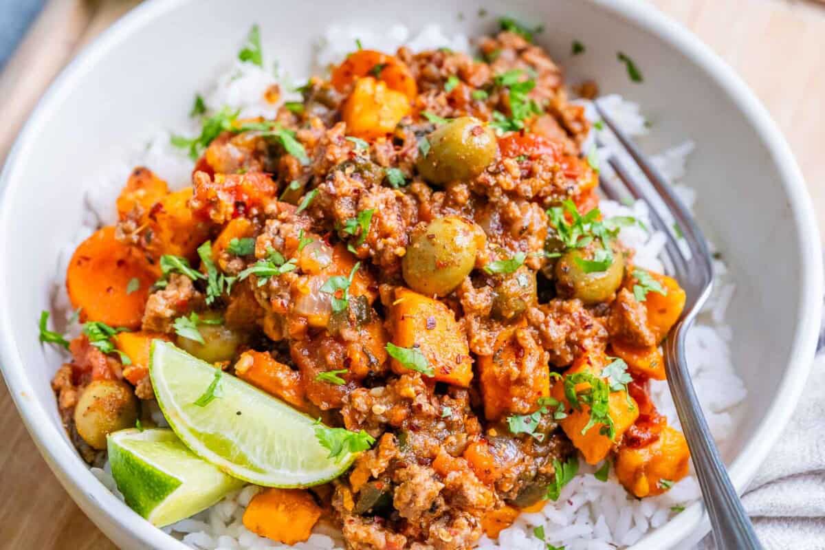 a bowl with mexican picadillo served over white rice.