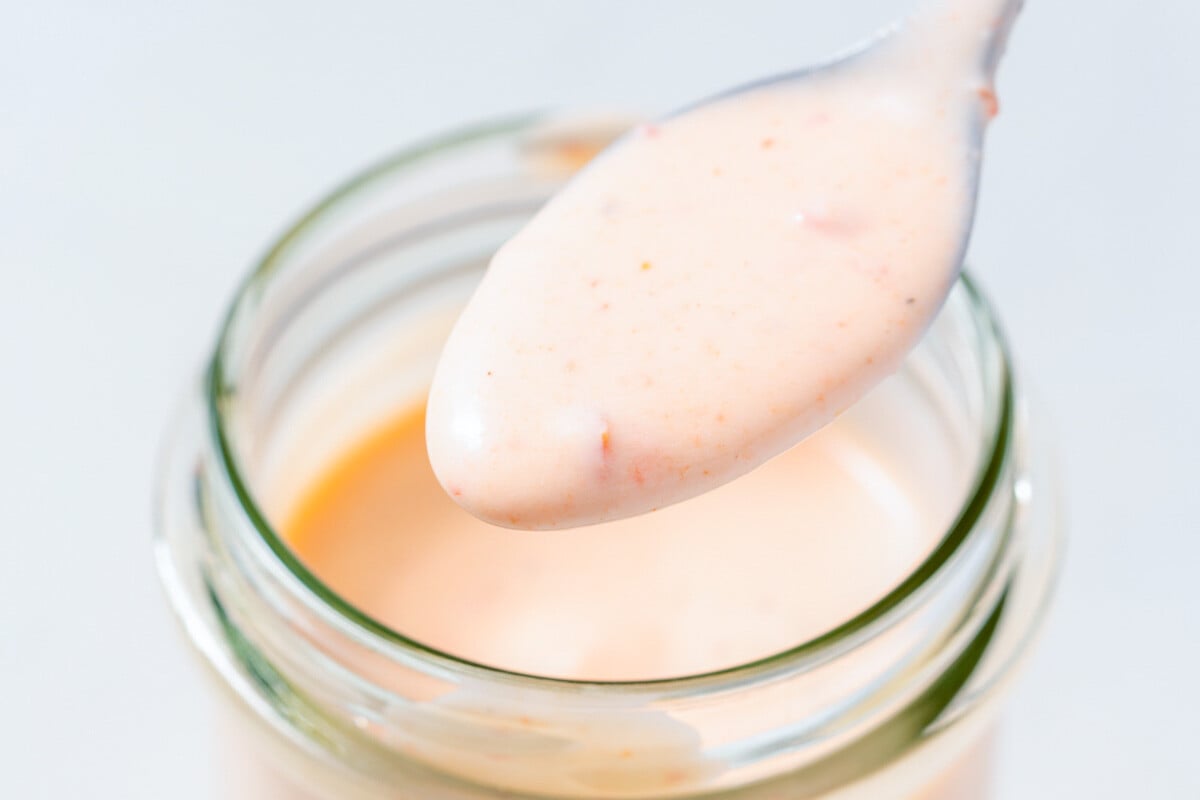 a spoonful of Bang Bang sauce over a jar.