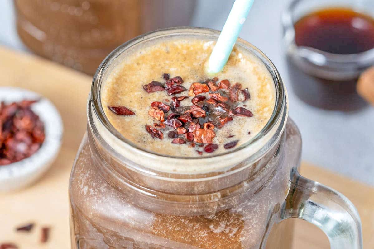 a jar with coffee shake topped with cocoa nibs.