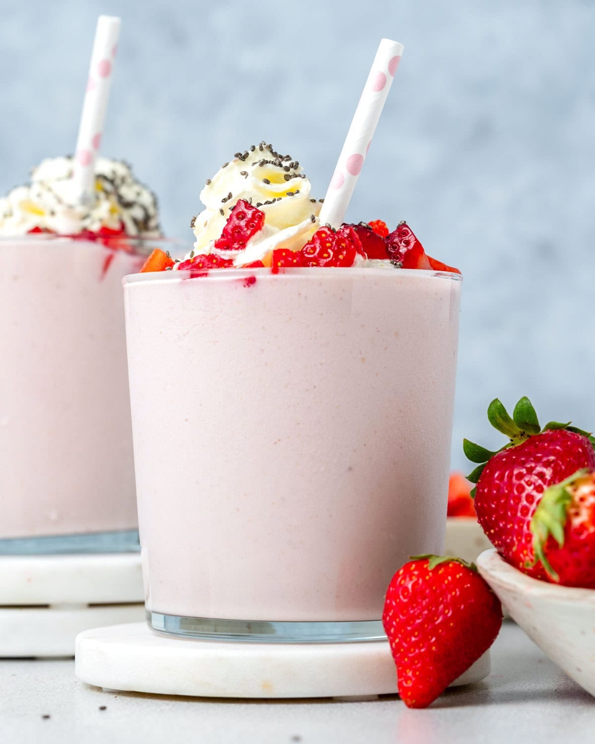 a cup filled with strawberry smoothie made with cottage cheese, topped with whipped cream.