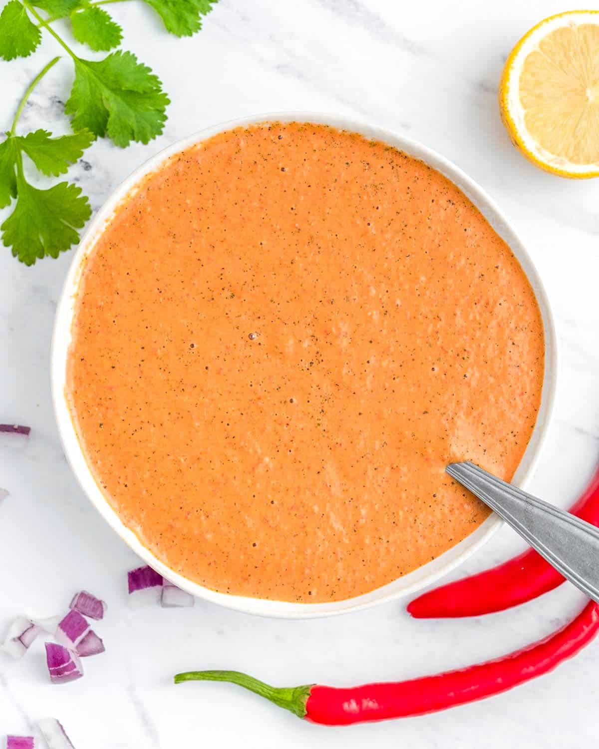 a bowl with peri peri sauce with a spoon in it. 