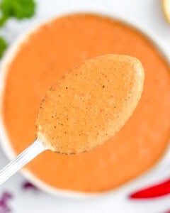 a bowl with peri peri sauce and a spoonful over the bowl.