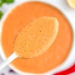 A spoonful of peri peri sauce over a bowl.