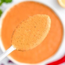 A spoonful of peri peri sauce over a bowl.