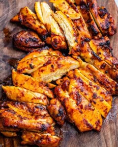 sliced chicken thighs on a cutting board.