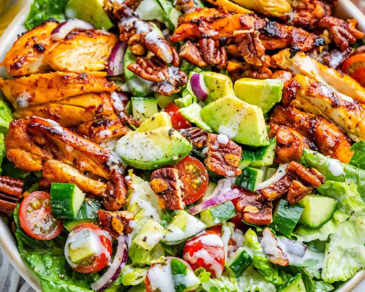 bbq chicken salad in a bowl drizzled with white dressing.