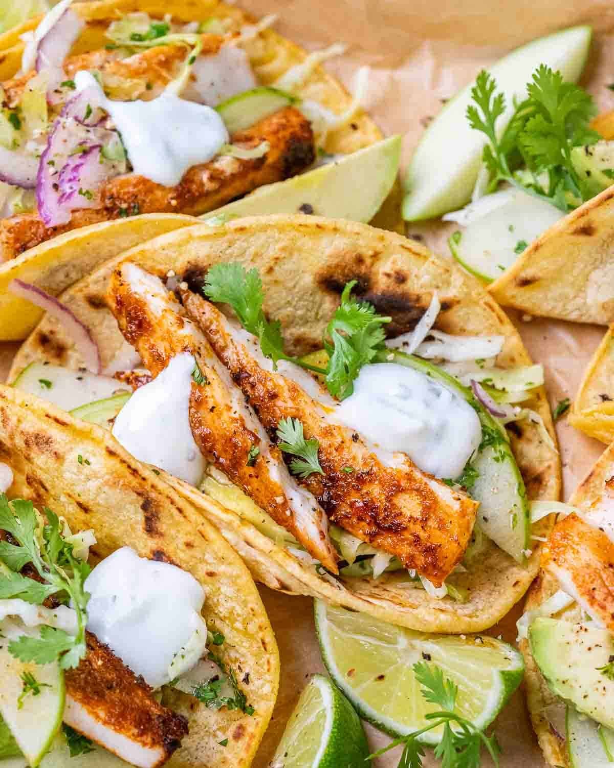 A close up of mahi mahi fish tacos with apple cabbage slaw.