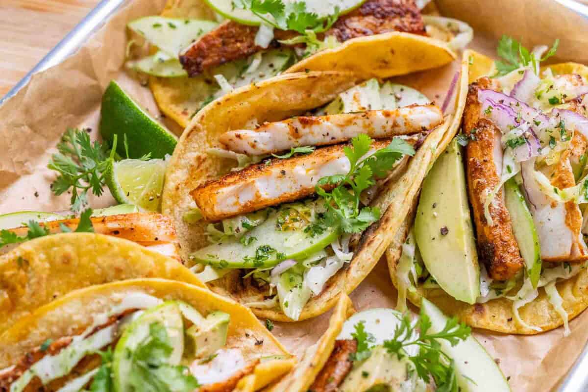 A close up of mahi mahi fish tacos with apple cabbage slaw.