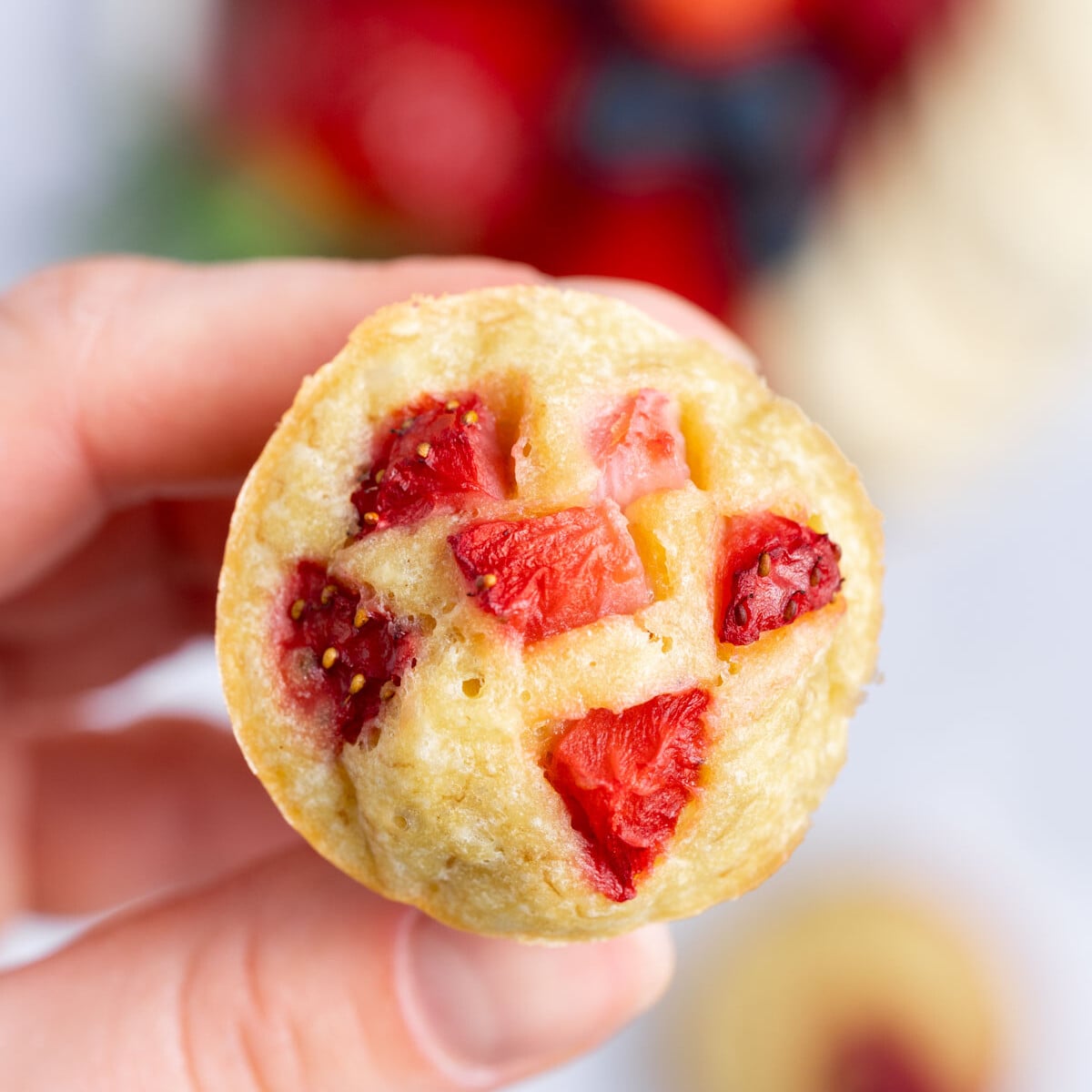hand holding a single mini muffin.