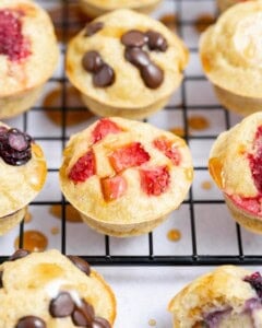 mini pancake muffins on a wire rack, topped with maple syrup.