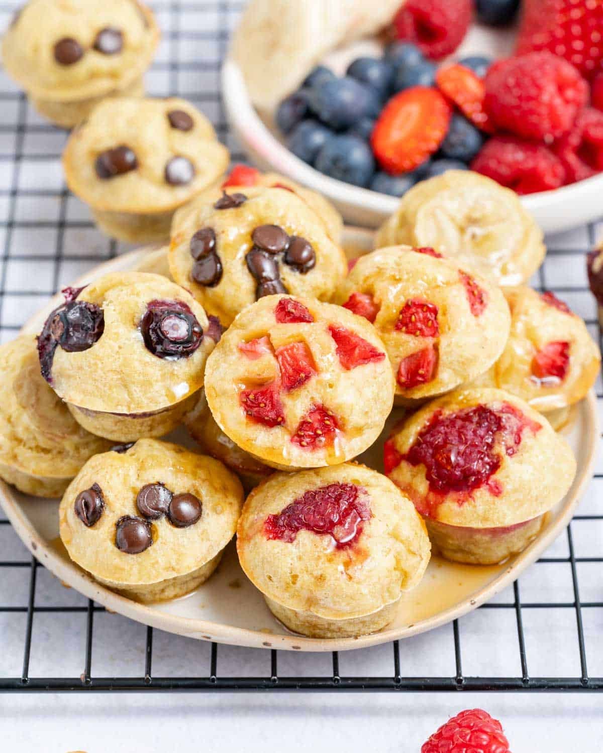 mini pancake muffins on a plate topped with berries.