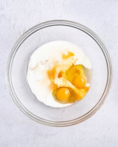 a bowl with eggs, oil, and milk.