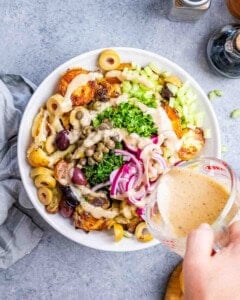 adding the dressing over the salad.