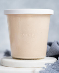 A jar of Yum Yum sauce on a white background with a white lid.