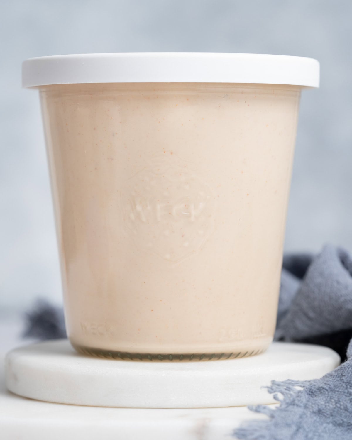 A jar of Yum Yum sauce on a white background with a white lid.