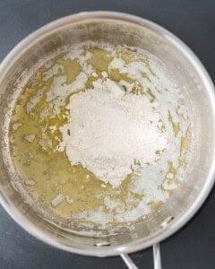 flour added over melted butter in a pan.