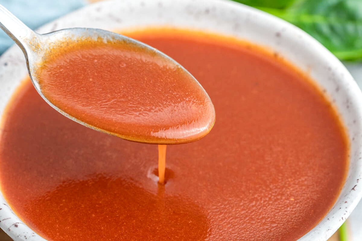 a spoonful of dressing over a bowl.