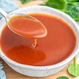 Close up of Catalina dressing being poured from a spoon into a small white speckled bowl.