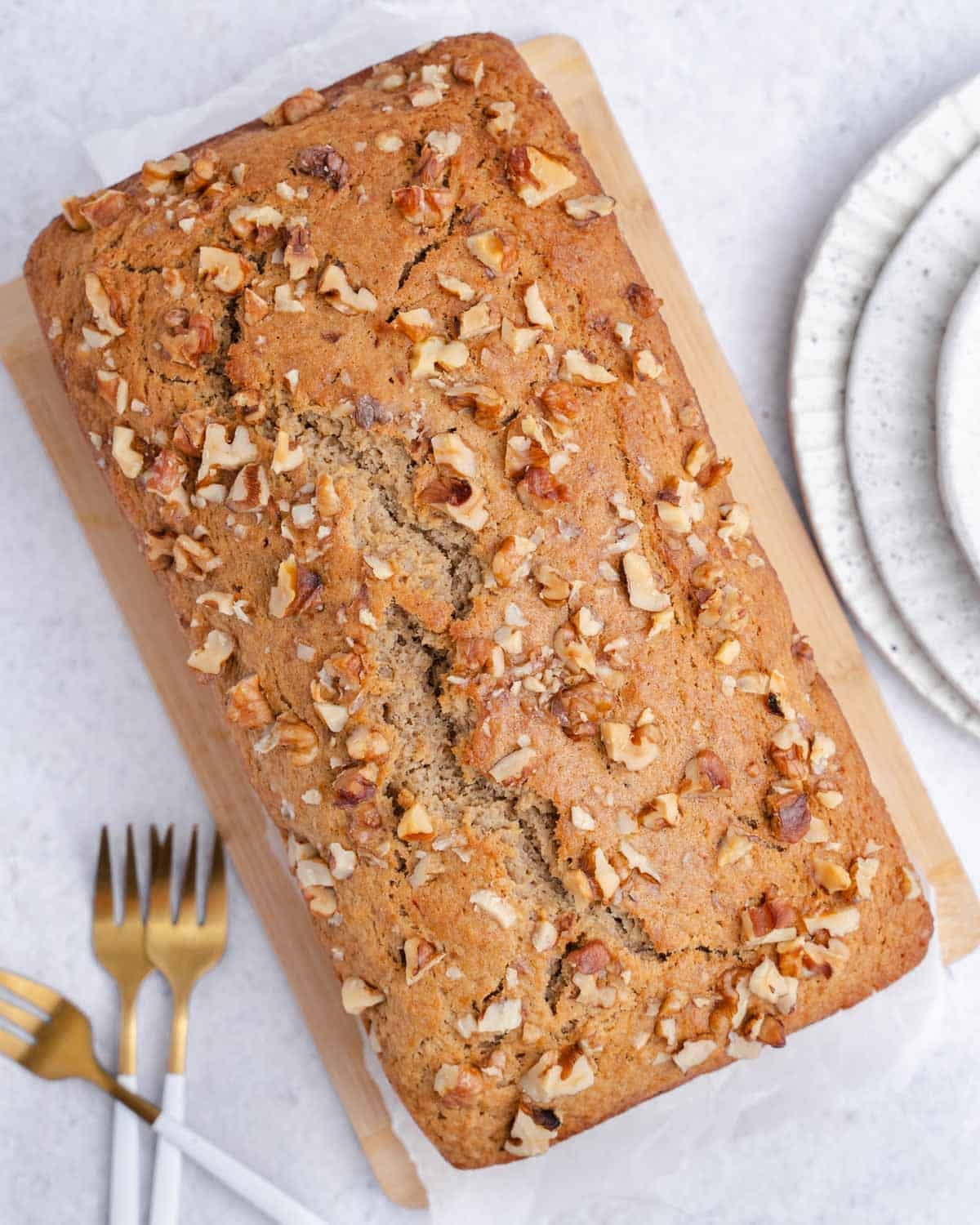a full whole apple sauce bread topped with chopped walnuts.