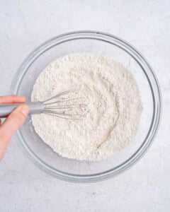 mixing the flour mixture for the applesauce bread in a bowl.