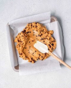 spreading cookie dough in a pan.