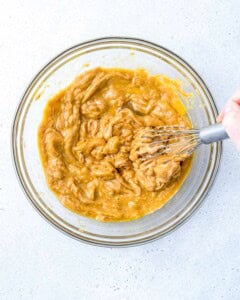 a bowl with peanut butter, eggs, and vanilla mixed until smooth.