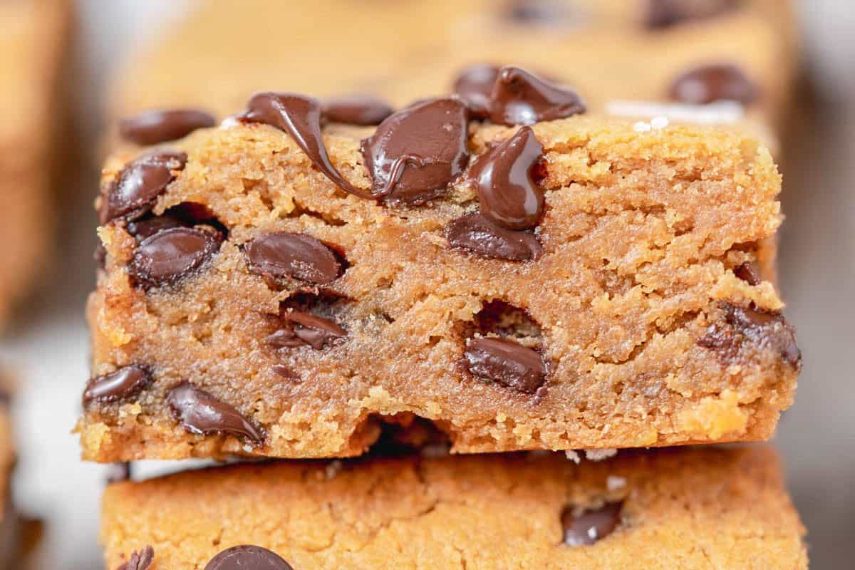 a cookie bar laid over another cookie bar with visible melted chocolate chips on it.
