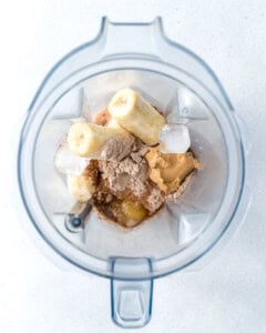 ingredients added to a blender to make peanut butter chocolate protein shake.