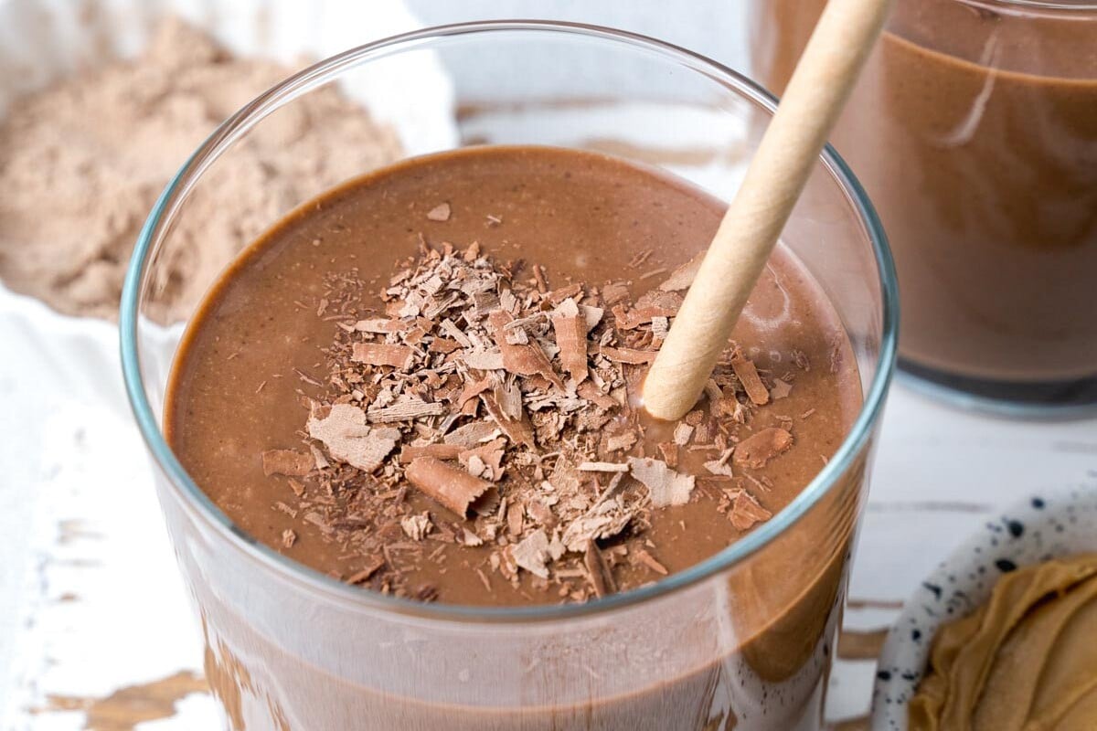 a straw in a clear cup with Chocolate Peanut Butter Protein Shake 