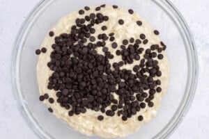 chocolate chips added over batter in a bowl.